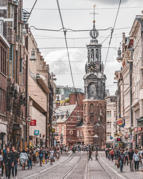 Amsterdam, Holandia - 21 lipca 2019: Przejazd tramwajowy z widokiem na wieżę mennicy Munttoren na końcu ulicy — Zdjęcie stockowe