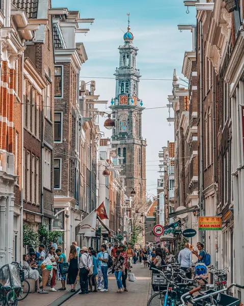 Amsterdam, Holandia - 21 lipca 2019: Turyści na ulicy z widokiem na wieżę kościoła Westerkerk — Zdjęcie stockowe