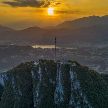 Monte Salvatore 'un gün batımını ve Varese köyünü gösteren hava aracı görüntüsü.