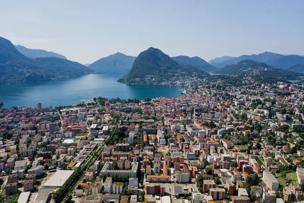 Aerial drone shot z Monte Salvatore, Lugano miasta i jeziora w słoneczny dzień — Zdjęcie stockowe