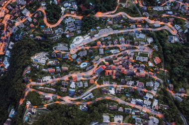 Overhead aerial drone shot view of winding mountain road street light on Monte Bre in Lugano, Switzerland clipart
