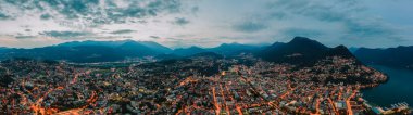 Lugano, İsviçre 'de göl kenarındaki sokak ışıklarının panorama hava aracı görüntüleri.