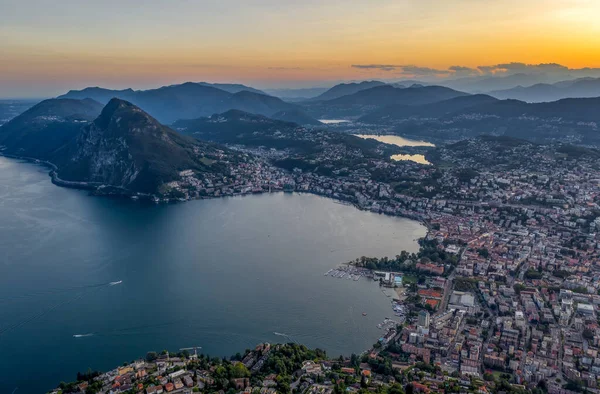 Uitzicht op drone vanuit de lucht voor zonsondergang van de Zwitserse stad Lugano en Monte Salvatore door Lago di lugano — Stockfoto