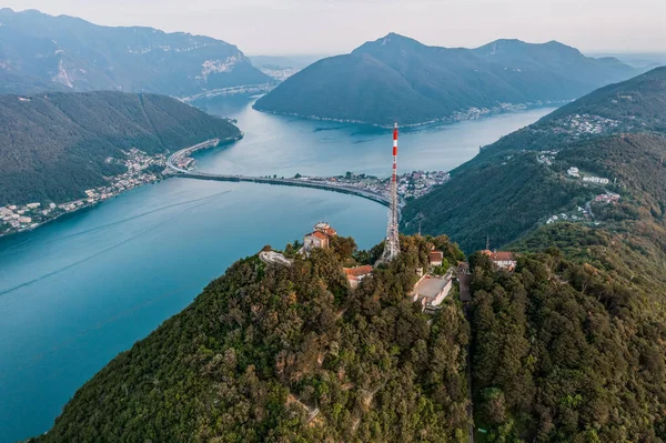 Αεροπλάνο drone άποψη της κορυφής του Monte Salvatore, San Giorgio, και γέφυρα diga di Melide στα ελβετικά ιταλικά σύνορα — Φωτογραφία Αρχείου