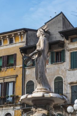 Verona, İtalya - 6 Ağustos 2019: İnsanlar sokakta eski bir ortaçağ Fontana Madonna Verona 'sının yanından geçiyor