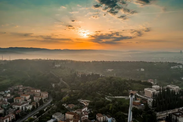 Aerial drone shot view of sunrise on foggy Veronetta colline with Castel San Pietro and funicolare — Zdjęcie stockowe