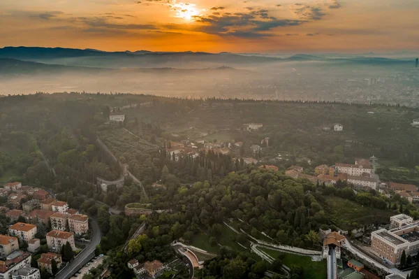 Aerial drone shot view of sunrise on foggy Veronetta colline with Castel San Pietro and funicolare — Zdjęcie stockowe