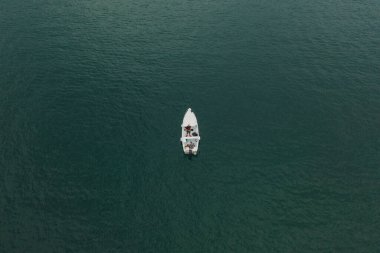 Malcesine, İtalya - 7 Ağustos 2019: Hava aracı Garda Gölü 'nde beyaz bir teknede iki adamın görüntüsünü çekti.