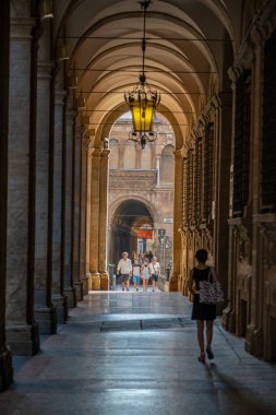 Bologna, İtalya - 8 Ağustos 2019: Peple Roma tarzı sütunlarla portico geçidinde yürüyor