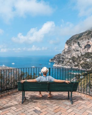Capri 'de, Augustus Bahçesi' ndeki Tyrhenian denizine bakan şapkalı bir adam oturuyordu.