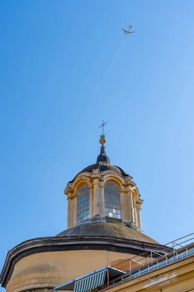 Plane in blue sky fly over church on the street of Naples — Stock Photo, Image