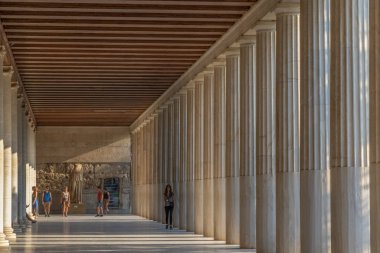 Atina, Yunanistan - 17 Ağustos 2019: Turistler antik Agora kentinin Attalos kentindeki mermer sütunlarla geçitte yürüyorlar