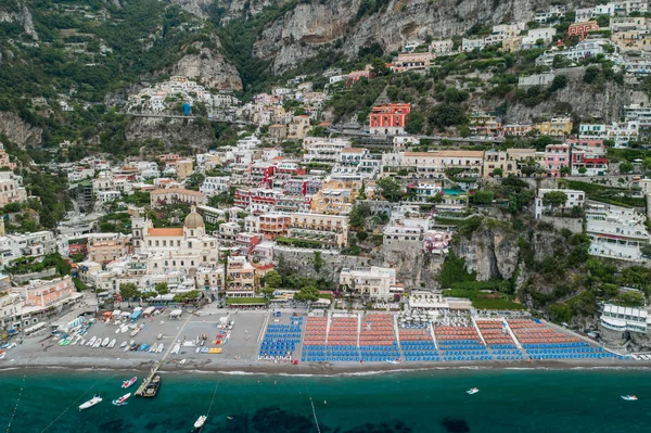 Luftdrohne schoss Blick auf positano Dorf und Strand mit Sonnenschirmen am Morgen in Amalfi-Küste, salerno — Stockfoto