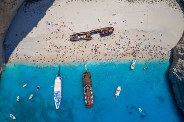 Yunanistan 'daki İyon Denizi' nde Zakynthos Navagio plajı turist ve yolcu gemisiyle dolu İHA 'nın tepeden çekimleri.