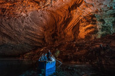 Kefalonia, Yunanistan - 22 Ağustos 2019: Melissani göl mağarasında derin bir kayıkta turistler