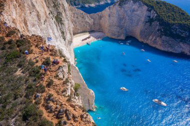 Zakynthos, Yunanistan - 20 Ağustos 2019: Gemi enkazı Navagio sahili kıyısındaki kayalıklarda turistlerin insansız hava aracı görüntüleri
