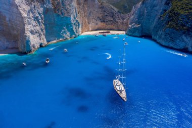 Zakynthos 'un yaz aylarında Navagio sahilinden kalkan lüks yatın insansız hava aracı görüntüsü.