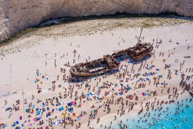 Turistler, gemi enkazı Navagio sahilinde terk edilmiş bir gemide yaz tatilinin tadını çıkarıyorlar.