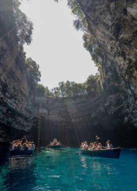 Kefalonia, Yunanistan - 22 Ağustos 2019: Turistler Melissani göl mağarasında teknede fotoğraf çekiyorlar
