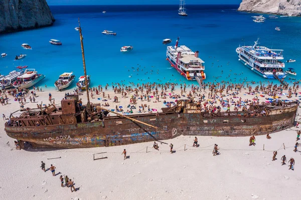 Zakynthos, Griekenland - 20 augustus 2019: Toeristen genieten van de zomer door verlaten roestig schip op schipbreuk navagio strand — Stockfoto