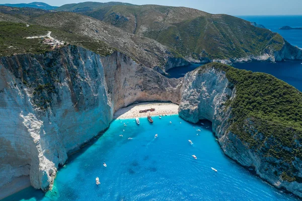 Flygdrönare skott av Zakynthos Navagio stranden med turister med kryssningsfartyg i blå joniska havet — Stockfoto