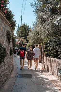 Capri, İtalya - 13 Ağustos 2019: Çiçek elbiseli turistler Capri Adası caddesinde yürüyor