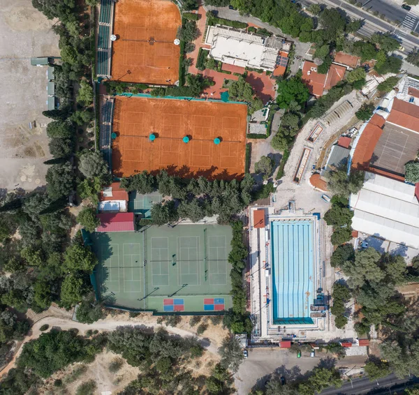 Zdjęcie lotnicze drona twardego i glinianego kortu tenisowego poza basenem w Atenach — Zdjęcie stockowe