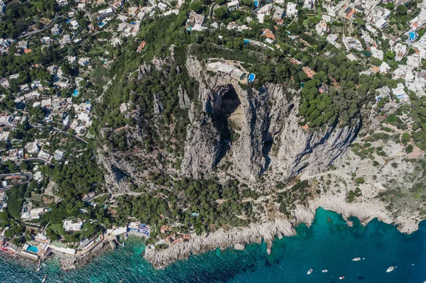 Повітряний дрон знімає гірську верхню віллу з басейном над великою печерою на південному острові Капрі. — стокове фото