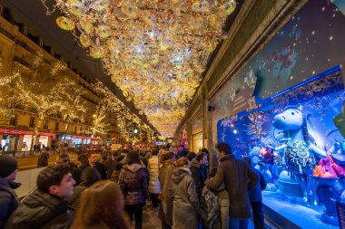 Paris, Fransa - 1 Aralık 2019: Parisliler Printemps butik vitrin vitrinine yılbaşı ışıklarıyla hayran kaldılar