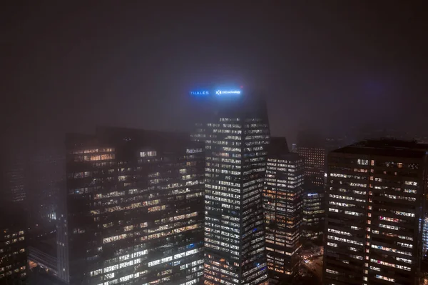 Parijs, Frankrijk - 5 december 2019: Aerial drone night shot of office in Tour Cbx, Thales Groupe, Dxc Technology in La defense in zware mist — Stockfoto
