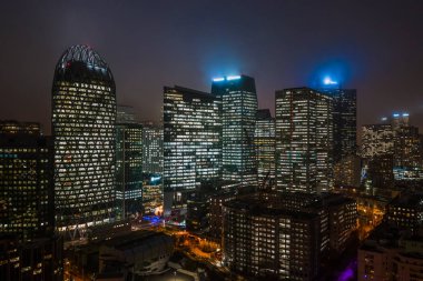 Paris 'in finans bölgesi La Defense' da gökdelenlerin ışıkları açık hava insansız hava aracı görüntüleri.