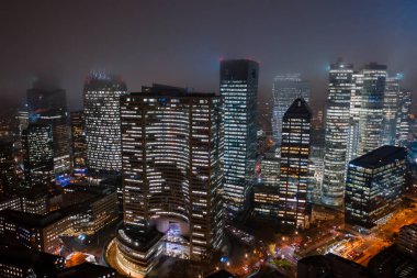 Paris La Savunma Bölgesi 'nde gökdelenlerin ışıklarla çekilmiş sisli hava aracı görüntüleri.