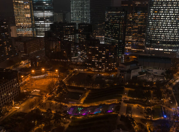 Aerial drone night shot of Parc Diderot with color lighted fountain with La Defense Skyscrapers in back