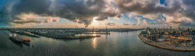 Gün batımından önce şiddetli fırtınalı bulutlarla birlikte Hafencity 'den Hamburg limanının panoramik drone görüntüsü