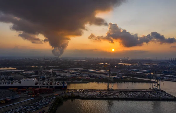 Widok z lotu ptaka Port w Hamburgu podczas zachodu słońca z dymem i ciężkimi chmurami nad stoczniami nad morzem — Zdjęcie stockowe