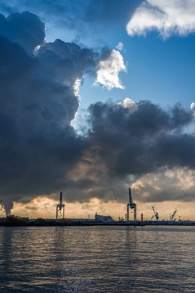 ハンブルクの港で石油精製クレーン嵐の雲と青空と海の調和 — ストック写真