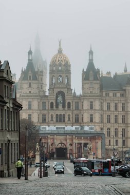 Schwerin, Almanya - 11 Kasım 2019: Schwerin Şatosu Kilisesi 'nin yoğun sis ve sis ile sokak manzarası
