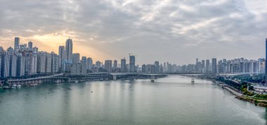 Chongqing, Çin - 22 Aralık 2019: Bulutlu bir havada yoğun ikamet alanı ile Jialing nehrinin üzerinde gün batımı