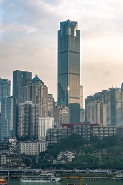 Chongqing, China - Dec 22, 2019: CBD Skyscrapers near Hongya dong cave by Jialing river in overcast weather clipart