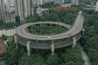 Chongqing, China - Dec 19, 2019: Aerial drone view of particular double circle flyover among residential buildings clipart