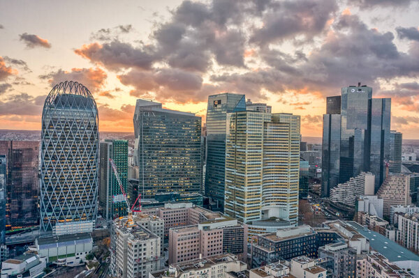 Aerial drone shot of La Defense skycraper CBD coomplex with park diderot in Paris with clouds during sunset