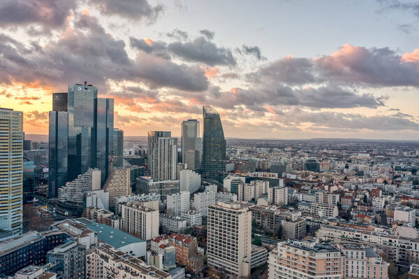 Aerial drone shot of La Defense skycraper CBD coomplex with park diderot in Paris with clouds during sunset