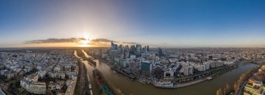 Gün batımında La Seine 'deki La Defense gökdelen kompleksinin hava pano görüntüsü.