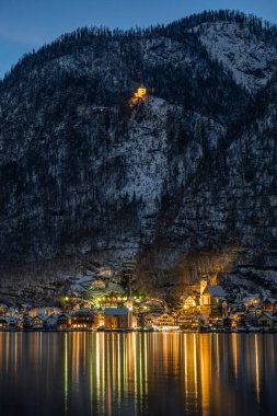 Güzel Avusturya köyü Hallstatt gölün kenarında kışın alacakaranlıkta karla kaplı