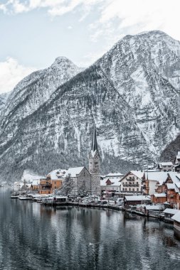 Karlı köy Hallstatt göl kenarında kar dağının eteklerinde kışın açık gökyüzü Avusturya 'da