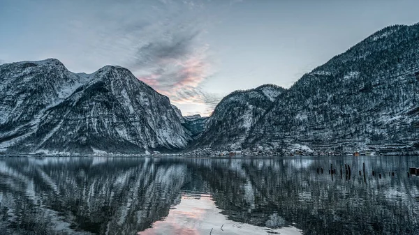 Pano widok przez jezioro Hallstatt zaśnieżonej wsi w czasie zachodu słońca w zimie w Austrii — Zdjęcie stockowe