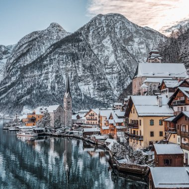 Karlı köy Hallstatt gölün kıyısında kar dağının eteklerinde kışın gökyüzü açık Avusturya 'nın yukarısında