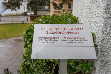 3 Şubat 2020 - Oberndorf, Avusturya: Stille-Nacht-Kapelle şapelinin dışındaki açılış saati bilgi panosu