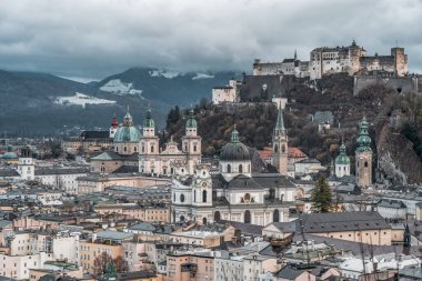 Salzburg şehrinin ufuk çizgisi tepelerdeki Hohensalzburg Kalesi manzaralı.