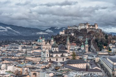 Salzburg şehrinin ufuk çizgisi tepelerdeki Hohensalzburg Kalesi manzaralı.